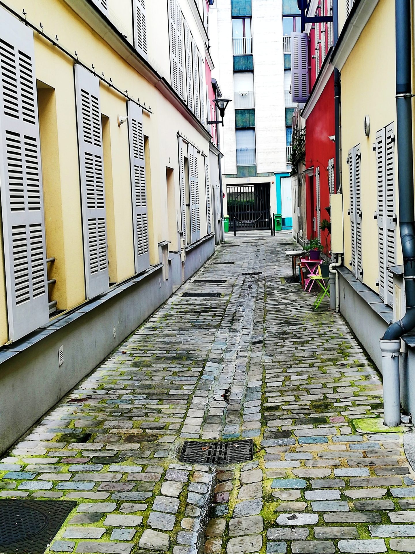 Beautiful cobblestones street in Paris with beautiful colorful houses on each side.